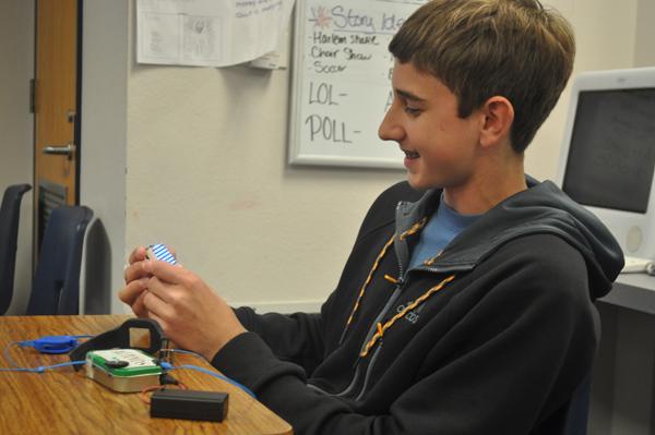 Freshman Alex Jones sits back to admire his gadgets. Recently he made his own watch and iPod out of simple household materials. 