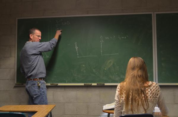 Mr. Alexander, an honors physics teacher, instructs sophomore Brianna Gioldert on how to find the change in time. Mr. Alexander has been a teacher at CHS for over 15 years and loves what he does. 