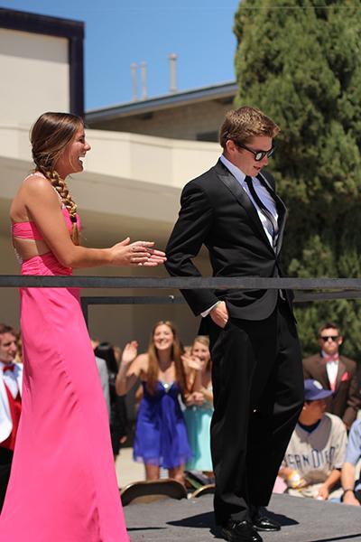 Juniors Spencer Beyer and Ashlyn Sprinkle show off their attire in the prom fashion show. Clapping as Spencer shows off his tuxedo from Friar Tuxs, Ashlyn shows the good spirit off all the fashion shows participants. 