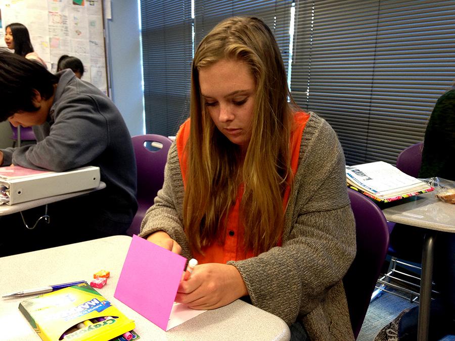 Junior Andrea Wagner  decorates a holiday card that will be given to a veteran. Red Cross Club participates in Holiday Mail for Heroes to brighten up the season for others. 