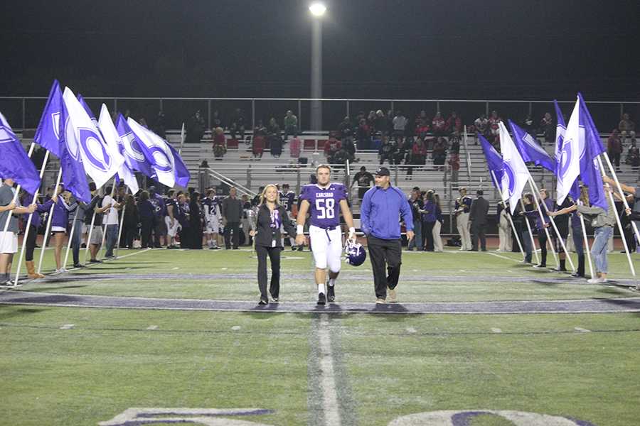 Damian Mirizzi is escorted by his mother and father on Senior Night, before the last home football game at Carlsbad of the 2013-14 regular season. Lancers came out on top over Vista with a 42-0 victory.