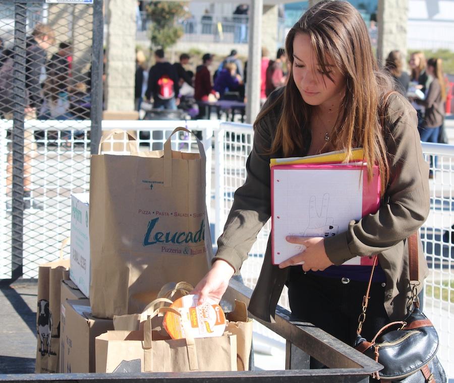 Senior Nicole Forth drops off non-perishable food for the Fillabus food drive during lunch in the quad.  Students were encouraged to donate anything they could and could even receive Lancer points for donating.