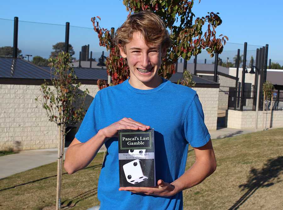 Justin Oetting holds his book Pascals Last Gamble. Justin co-authored the book with his father, Steve Oetting, as only a sophomore!