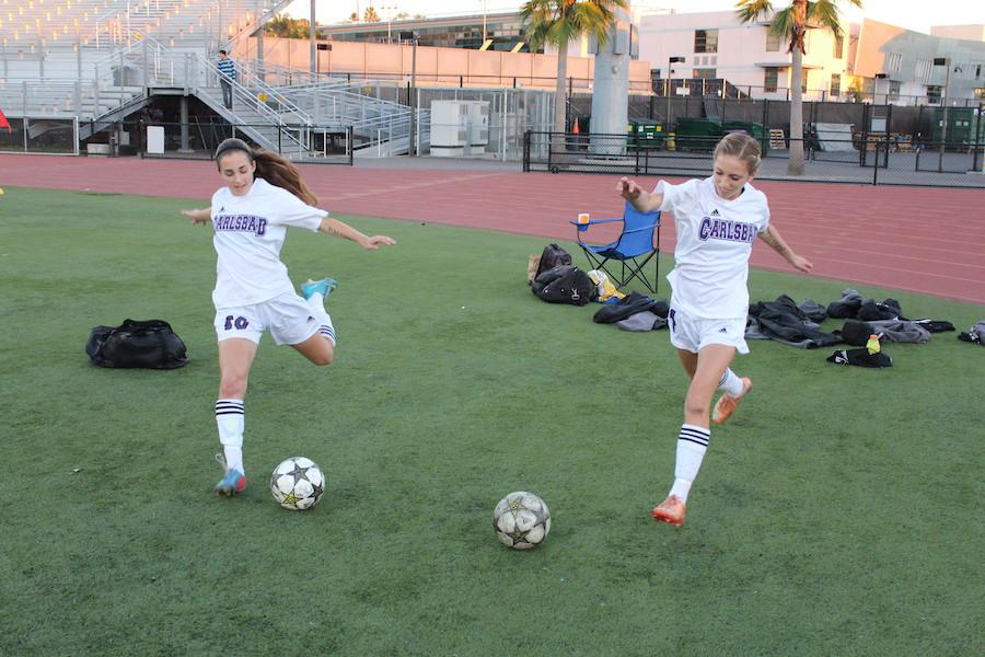 Freshman, Caitlin McCarthy (right) and Erin Sinai (left), practice their kicks before the Westview game. Both girls hold impactful positions on womens varsity soccer. 