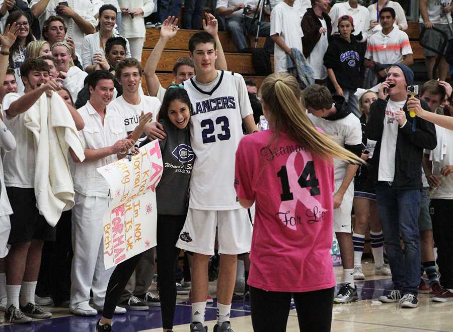 Senior Victoria Soto asks varsity basketball player Taylor Bloomquist to formal at the end of the white out game with a decorative sign and a crowd cheering them on. Carlsbad girls have been creatively asking their date in the last couple weeks, leading up to formal next Saturday.