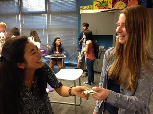 Club member, Kaylin Brennan, hands senior and president of Red Cross Club, Masami Amakawa, money collected for the Measles Initiative. Every year Red Cross Club participates in the Measles Initiative to raise money for less fortunate children who cannot afford to pay for measles vaccines. 