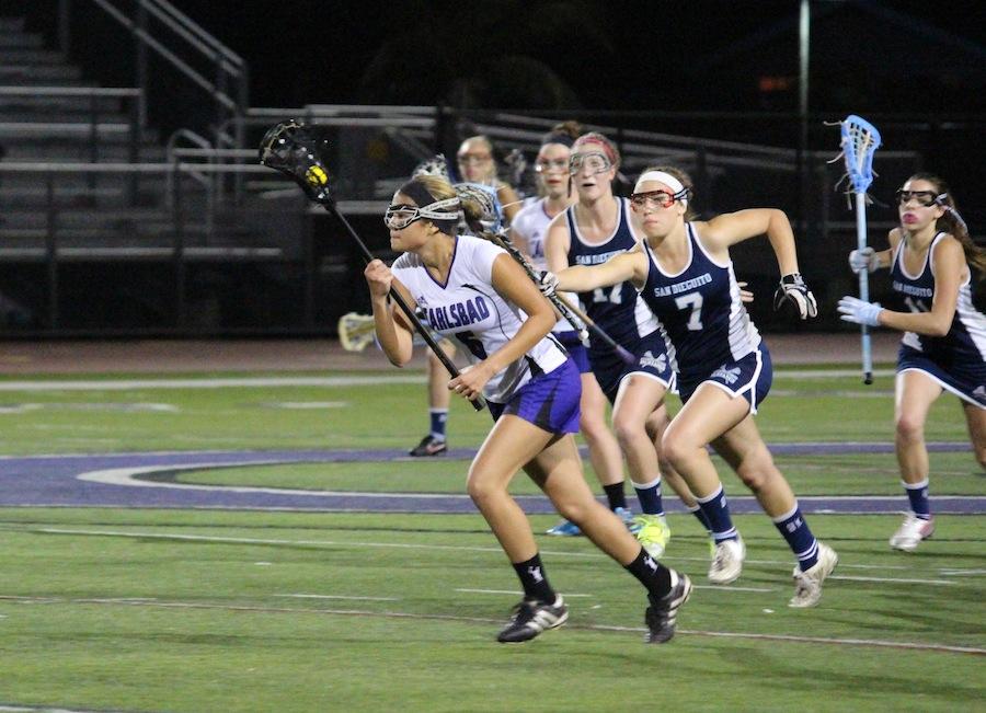 Courtney Haubach sprints the ball downfield in a game against San Dieguito Academy on Mon. Mar. 10.  Girls varsity lacrosse secured a win in their first game of the season.