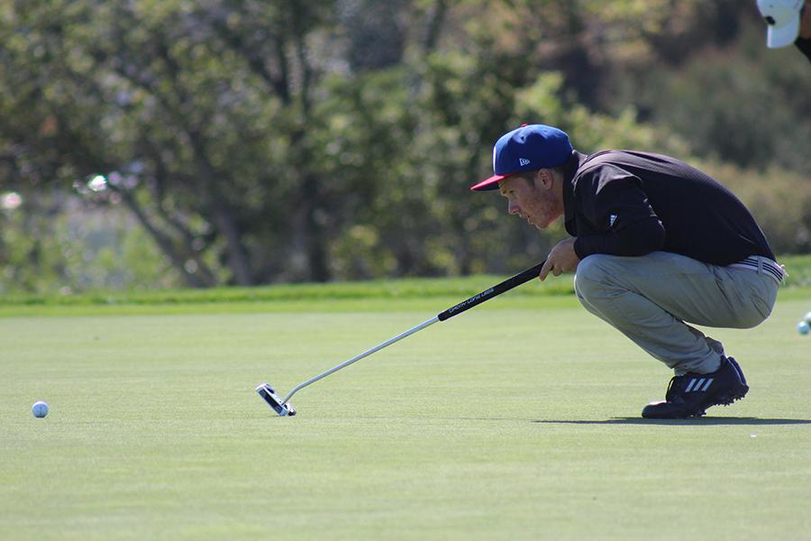 Senior Taylor Smith measures up to putt/ 