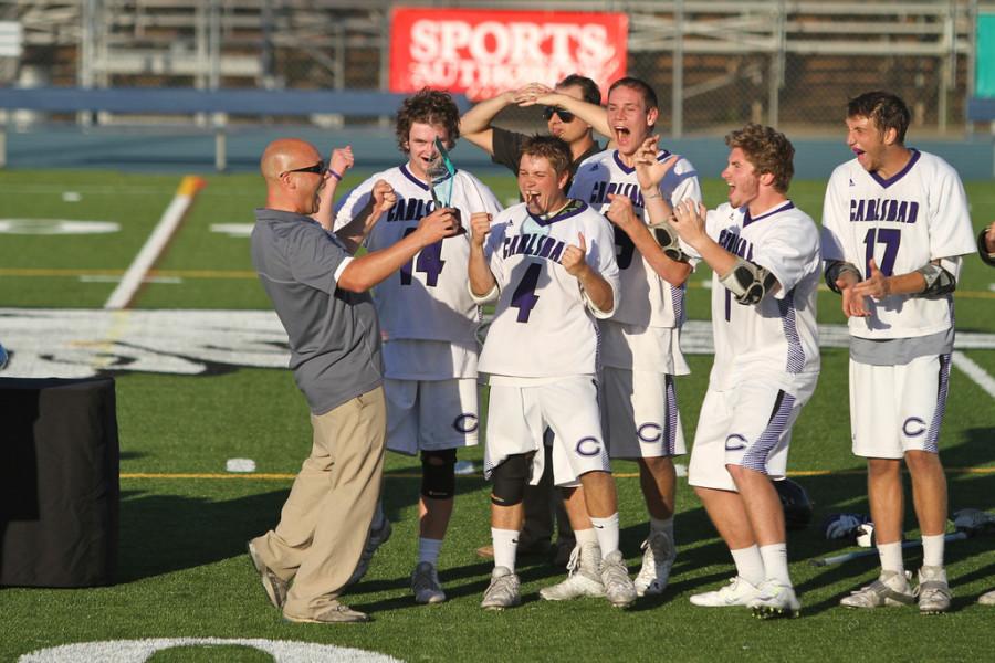 Head coach Dave Demuth displays the trophy to the rest of the team. Coach Demuth led Carlsbad in his first season as head coach and won the Division 1 Championship. 