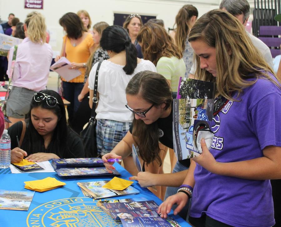 Senior Dorin Coffler and other prospective college students fill out college information at College Night.  There were several colleges as well as after high school career booths in both the old and new gyms.