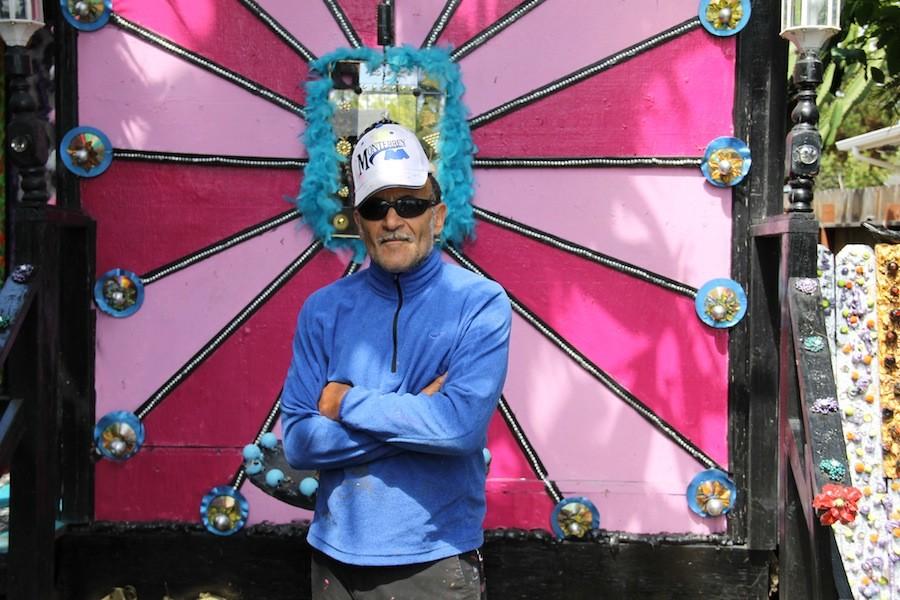 The artist, Richard Margolin, stands in front of his main centerpiece. Some recurring themes in his work include the use of bright colors and faces to give his art the liveliness it needs. 