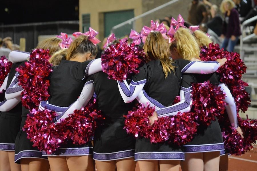 Carlsbad cheerleaders huddle to get hyped for OT.  During the month of October cheerleaders and football players wear pink in support of breast cancer awareness.