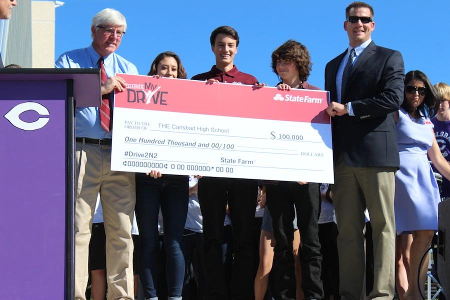 Seniors Sydney Payne, Joey Szalkiewicz and Nick LaMarca accepted the State Farm check for $100,000 for winning the two hands on the wheel and two eyes on the road video challenge. The lunch assembly took place on Tuesday, Dec. 8. 
