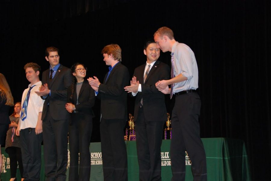 Members of Carlsbad High Schools nationally ranked speech and debate team stand on stage waiting to accept awards for the events that they placed in.