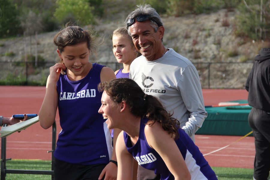 Coach+Manny+congratulates+senior+Sam+Schneider+as+she+finishes+the+4X400+relay+race+at+Sage+Creek