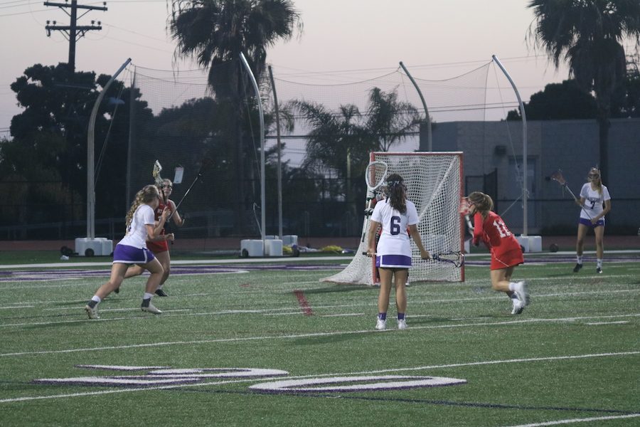Senior, Mackenzie Frost takes on a Mount Carmel defender nearing the end of the game. Last Friday, April 14, girls lacrosse played against Mount Carmel.