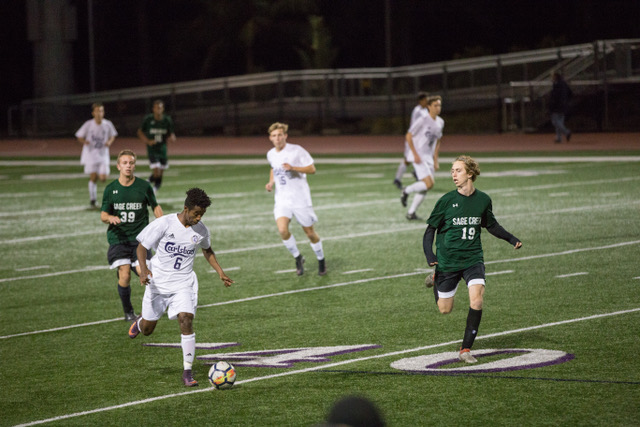Senior Aman Mikel dribbles up the field looking to dribble past some Sage Creek players during the Varsity game Friday Feb. 16. The Lancers went on to beat the Bobcats 
1-0.