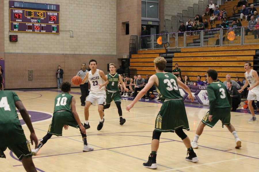 Junior Carter Plousha drives down the court looking for opportunity from his teammates in the paint. This is Carters second year playing on varsity basketball for Carlsbad