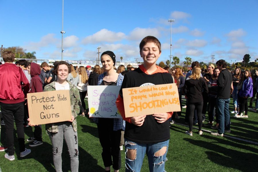 Sophomore Dylan Phillips is all smiles holding his homemade sign with his friends support for the walkout. The sign brings some humor to the unfortunate topic.