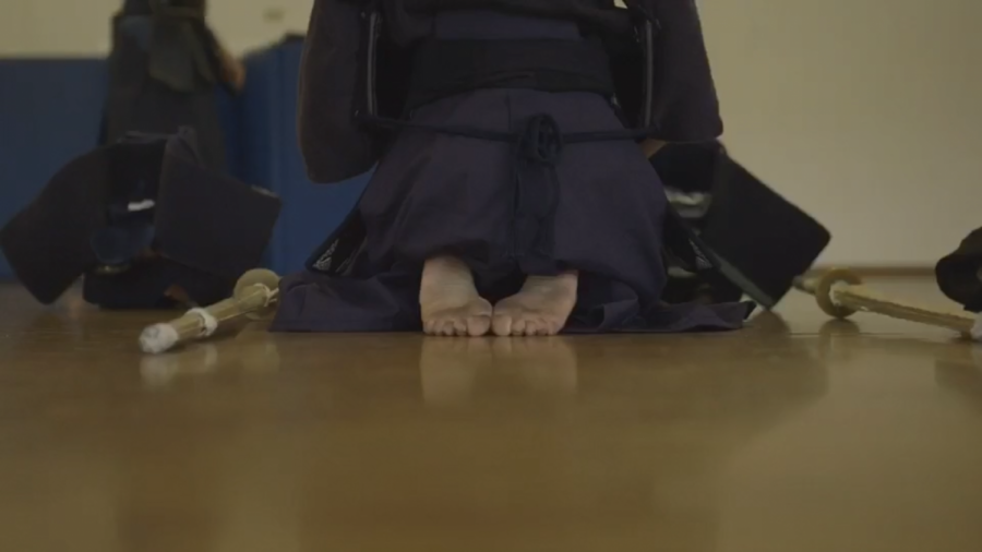 Collignon kneels on the ground during a more symbolic ritual of Kendo. 