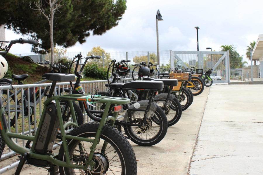 During school hours, a row of e-bikes line the bike racks inside of the Carlsbad High School campus.