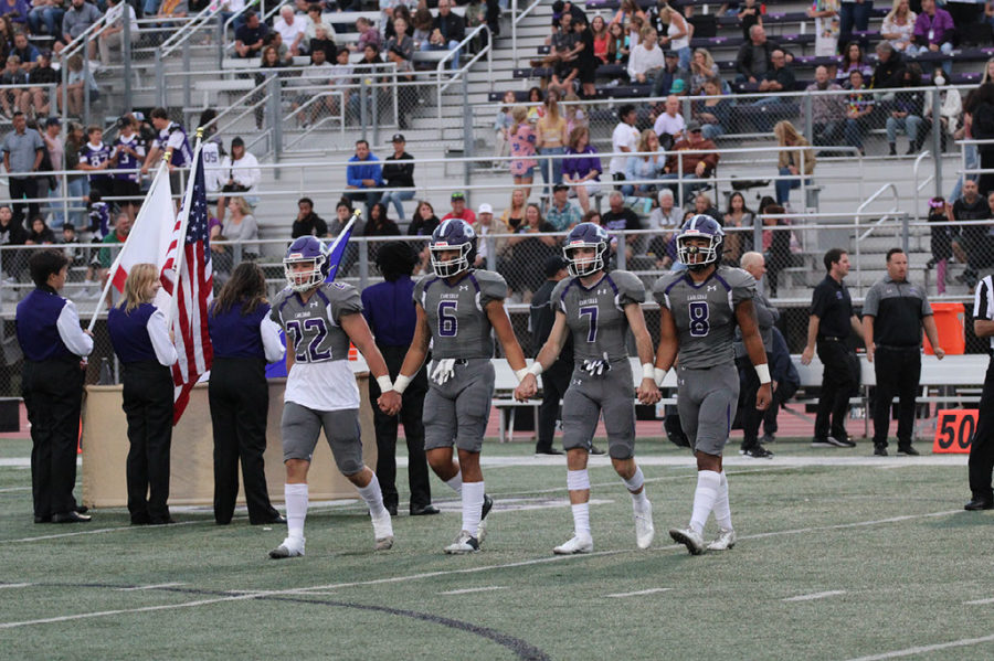 Captains head toward the center of their field for the coin toss. 