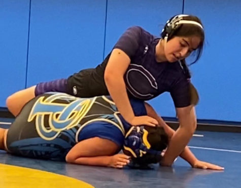 Senior Yessenia Sanchez pins an opponent during a match. Sanchez holds the pin, earning her a win.