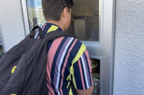Freshman Luca Artiglio receives lunch from the cafeteria window.
