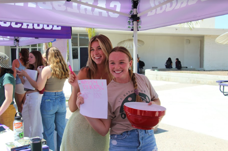 Happy Period Club representatives, Junior CarlyRae Jones and Senior Bella Lipsey, run their club stand at CHSs annual club fair. Many club tables have bowls of candy to offer to new members. 
