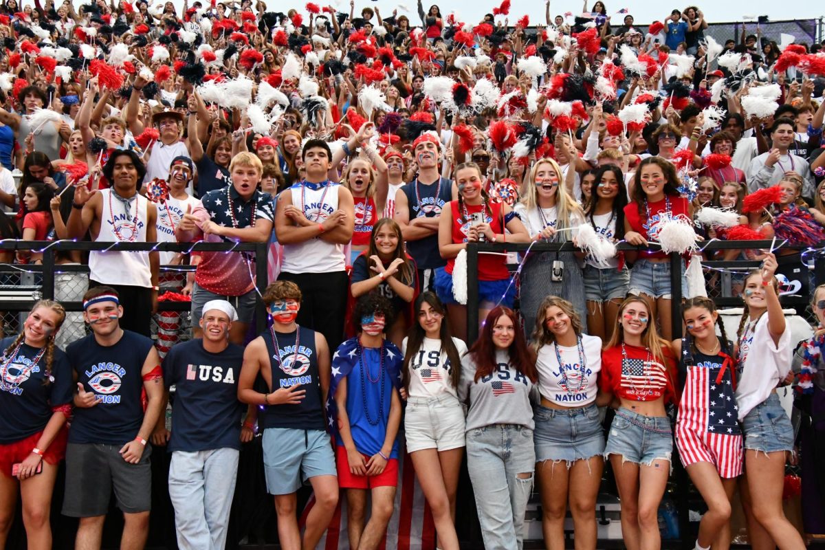 The+four+exchange+students+participated+in+the+USA+game+festivities+on+the+field+with+Loud+Crowd+on+Sept.+15.+They+are+pictured+in+the+center%2C+garbed+in+USA+gear.