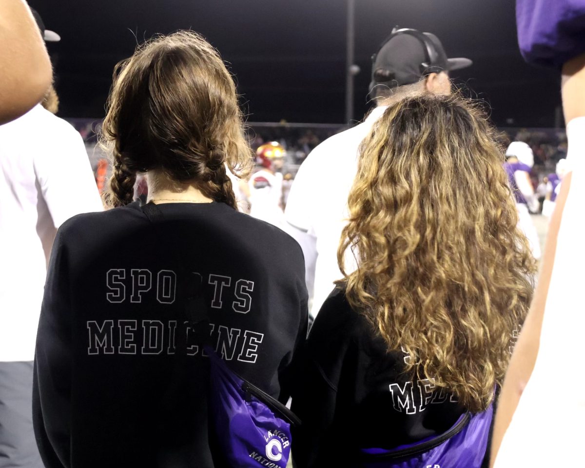 Sports Medicine students Eva Huebner and Erin Oswalt-Fallas watch for injuries on the sidelines of a varsity football game. 