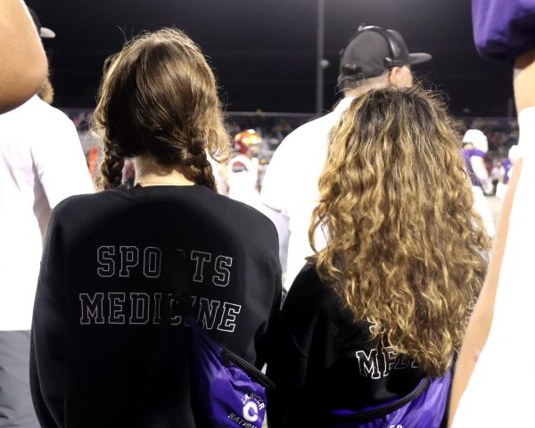 Sports Medicine students Eva Huebner and Erin Oswalt-Fallas watch for injuries on the sidelines of a varsity football game. 