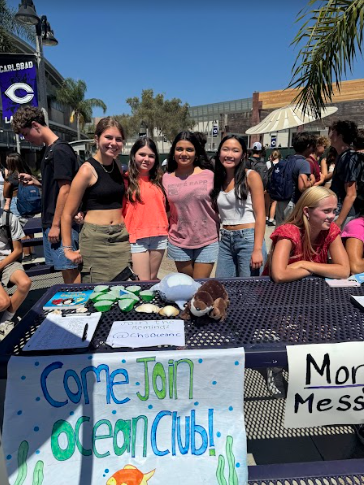 Club leaders Kirstyn Limsico and Kaily Alvarez gather around the Ocean Club's table at the Club Fair.