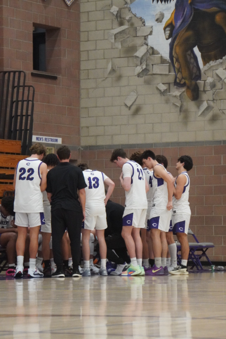 Carlsbad's boy varsity basketball in a mid-game huddle