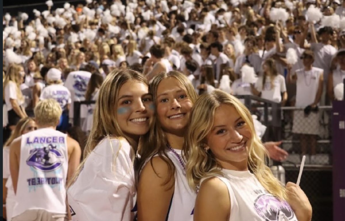 Senior class president Tessa Wolfe (left) alongside junior president Courtney Clemons (center) attending white out football game.