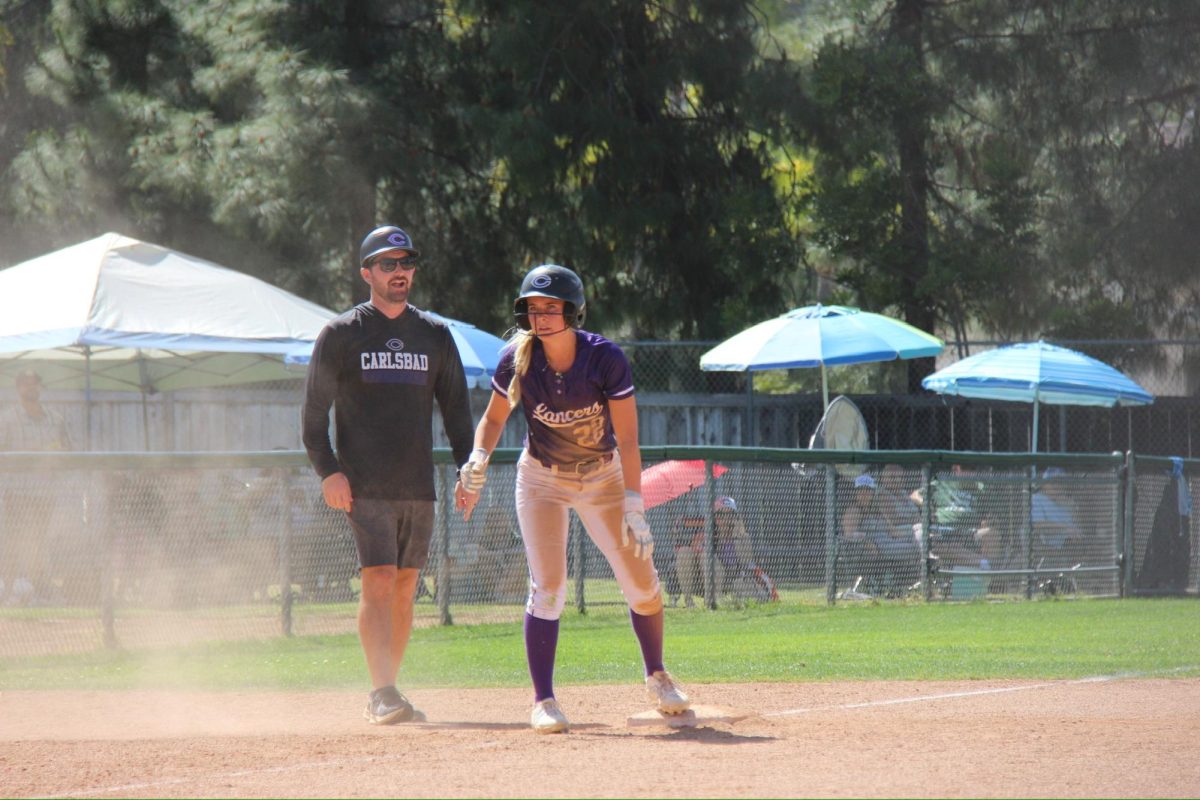 Coach Jared Miller in intense game coaching senior Grace Lehman on third base.